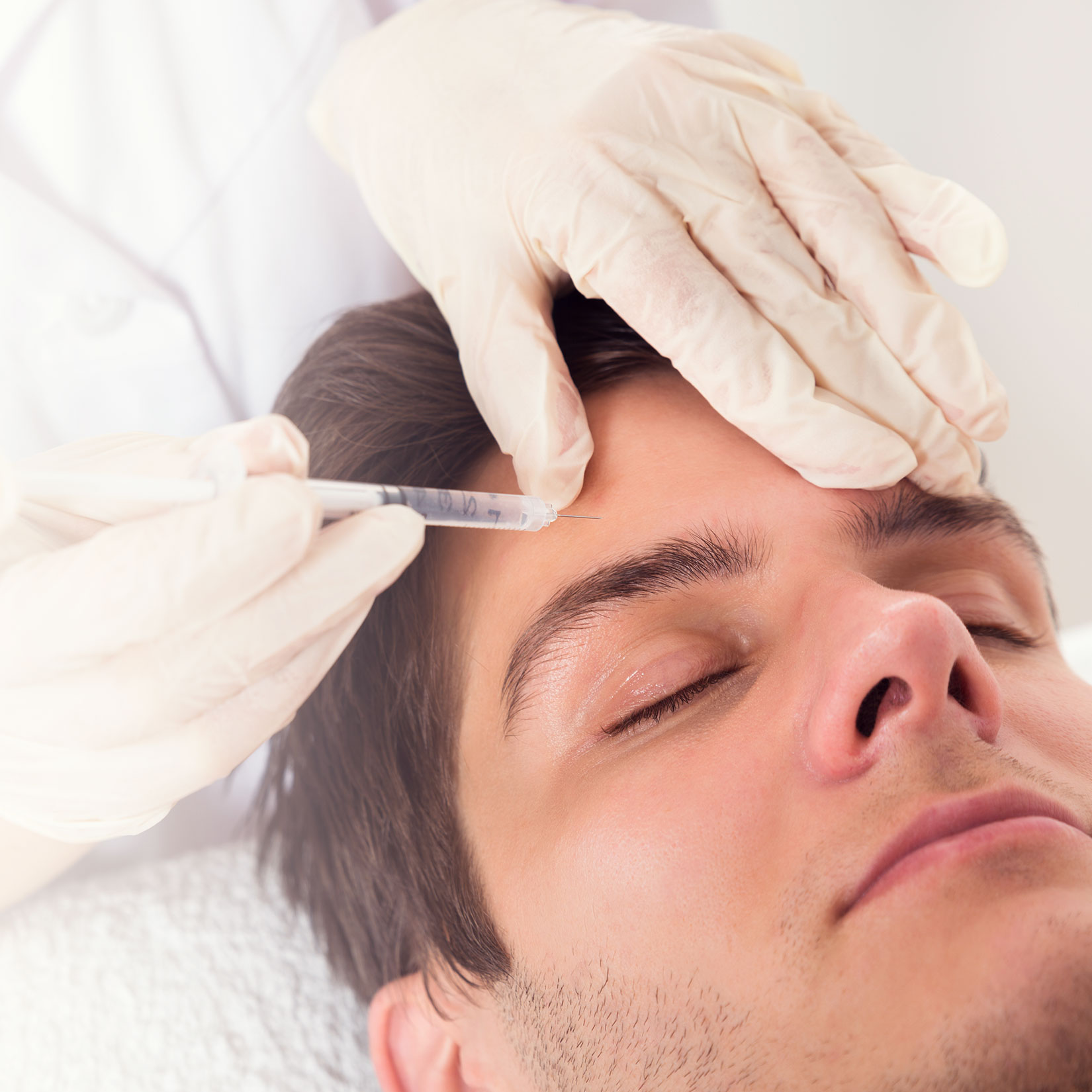 man getting a needle injected into his forehead