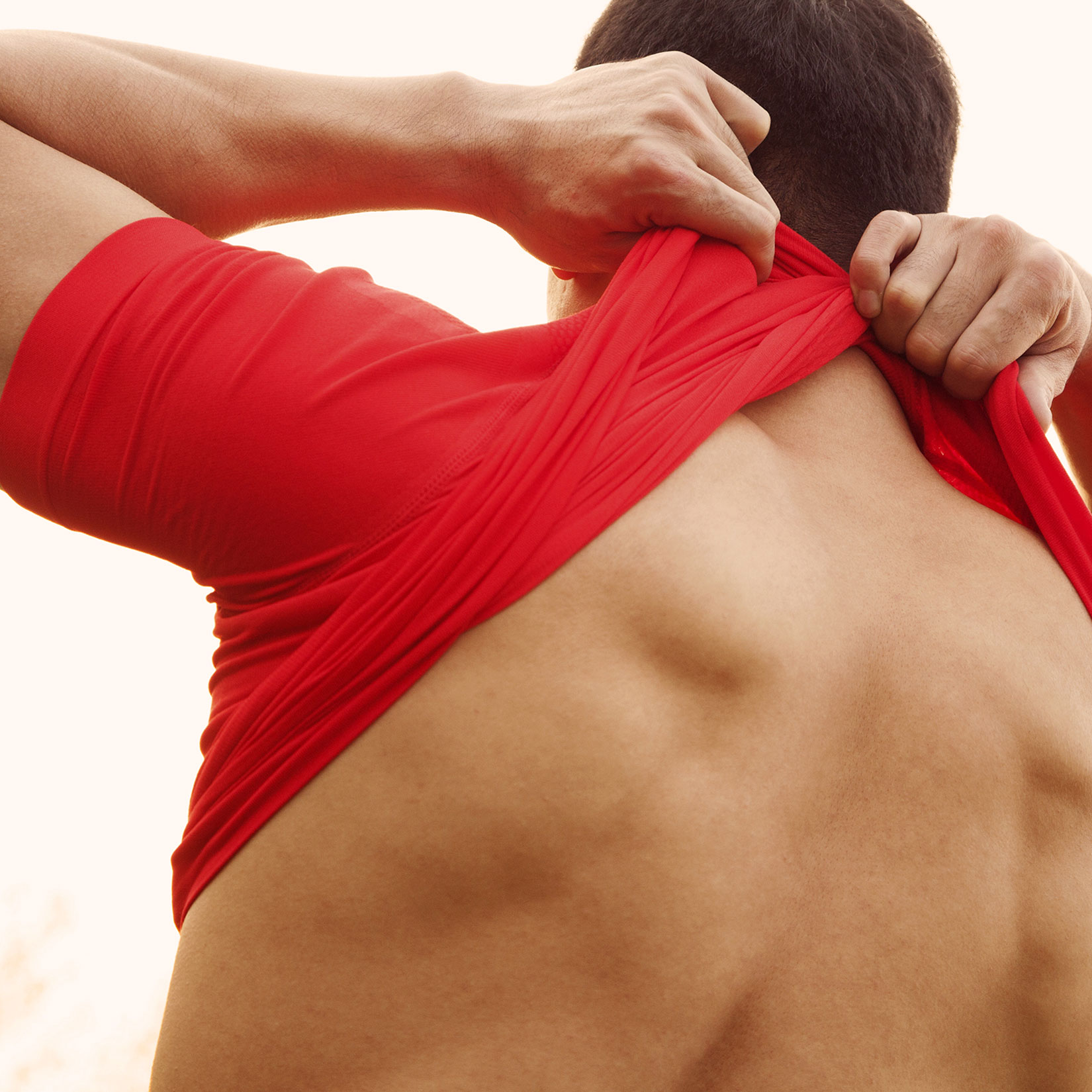 fit man's back while he takes his shirt off