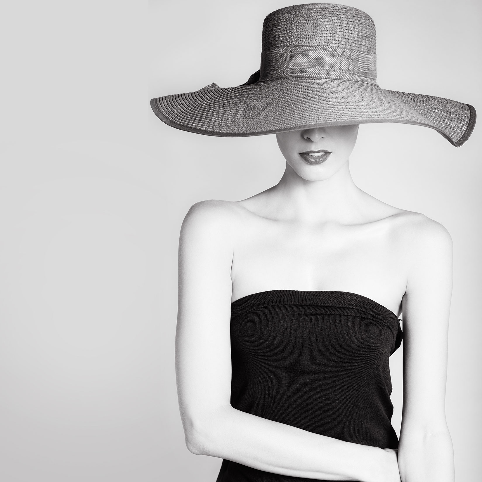 black and white photo of woman with large sun hat