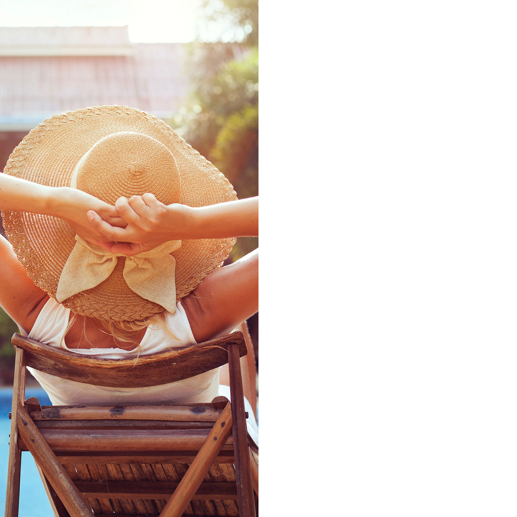 woman lounging outside with a sun hat on and hands behind her head