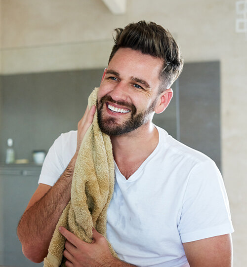 man drying face and smiling