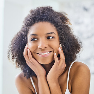 woman looking at smooth skin in mirror