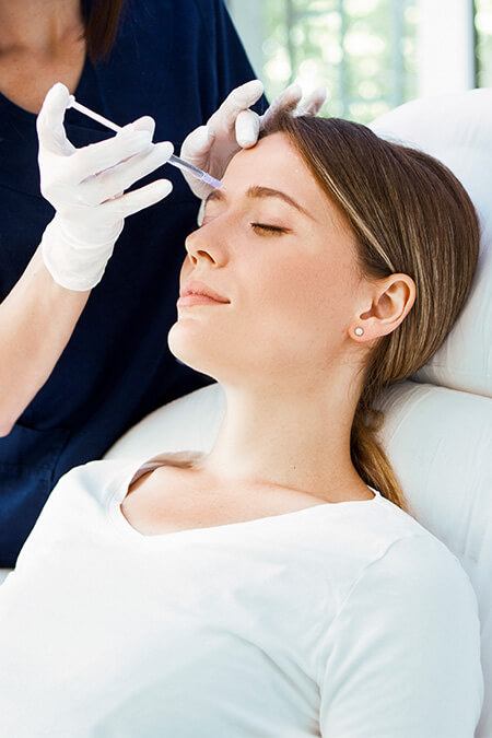 woman receiving forehead botox treatment